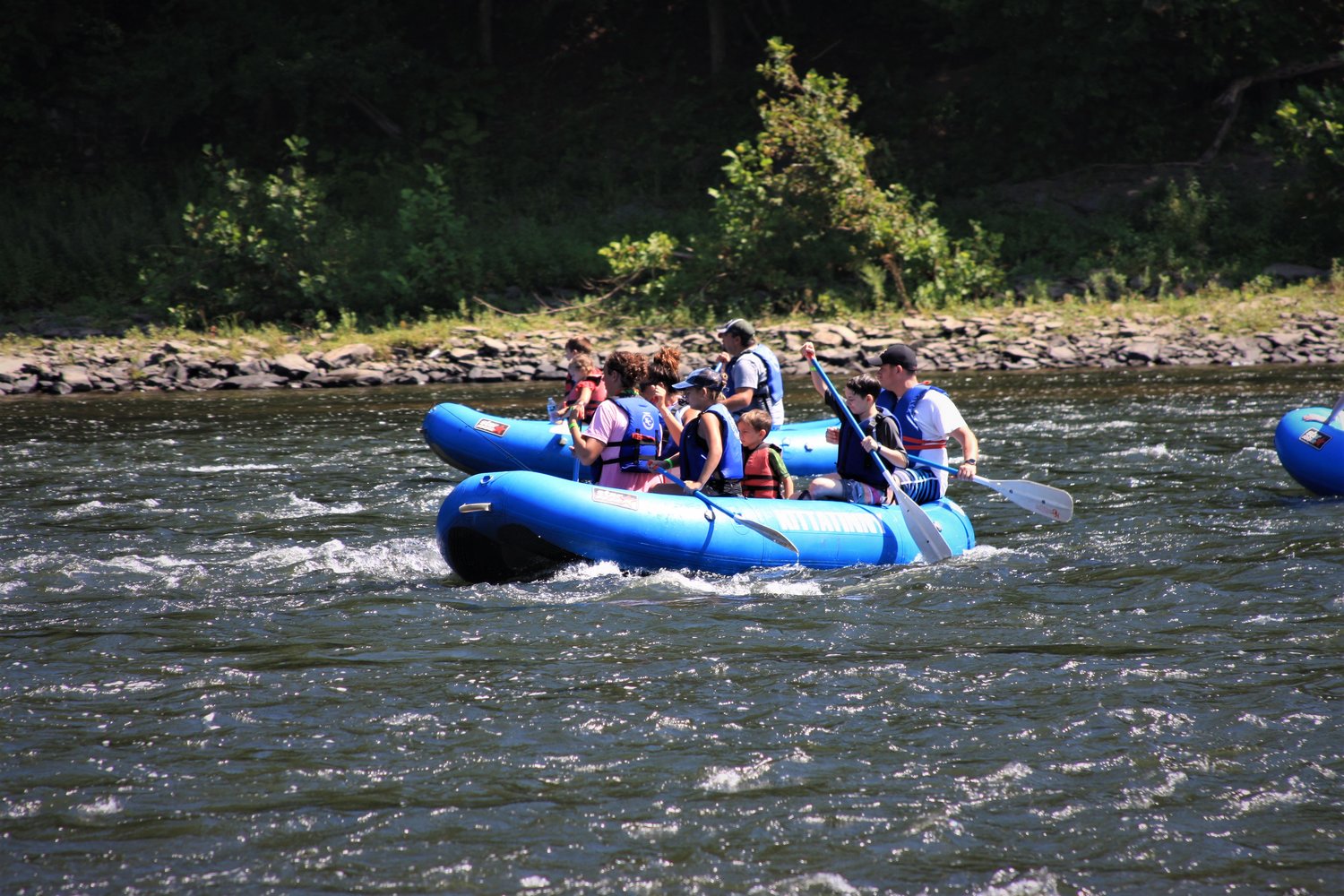 Boaters enjoying a rafting trip while wearing their life jackets.